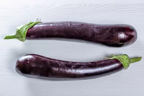 Top view of two purple eggplants on a white table