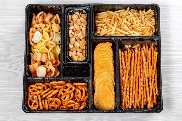 Top view of various beer snacks small pretzels, peanuts, potato chips (Flip 2019)