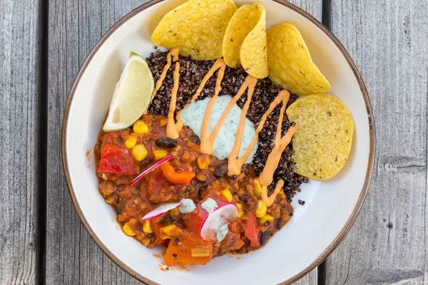 Top view of vegan Mexican food on Mallorca: Tex-Mex stew with black beans, corn, quinoa and nachos
