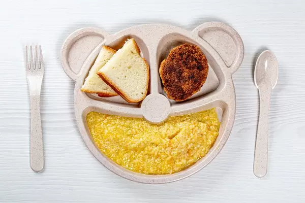 Top view of wheat porridge with a meat Patty and white bread