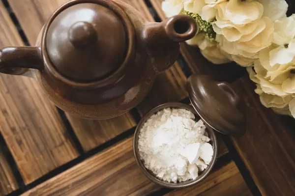 Top view of white powder and teapot on a wooden surface (Flip 2019)