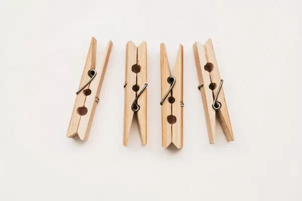 Top view of wooden clothes pegs on white backround