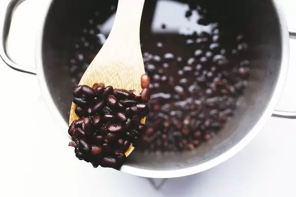 Top view of wooden spoon of cooked black beans