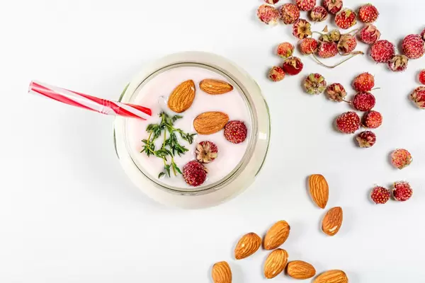 Top view of yogurt with strawberries and almonds on a white background (Flip 2020)