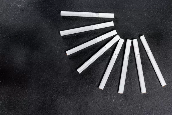 Top view on black cigarette background. The concept of addiction