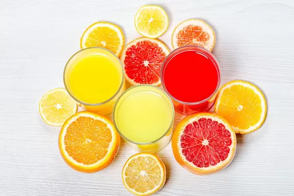Top view orange, lemon and grapefruit juices with slices of fresh citrus (Flip 2019)