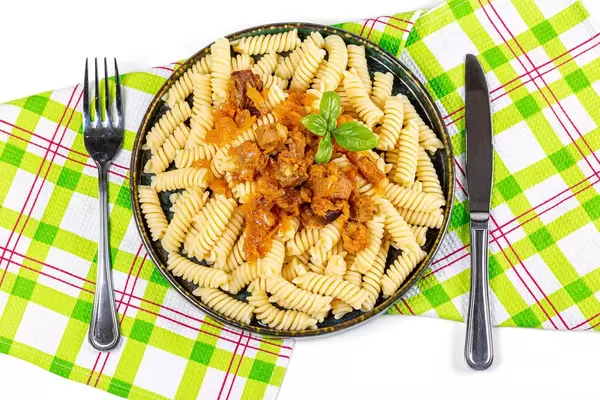 Top view, pasta with knife and fork on kitchen towel
