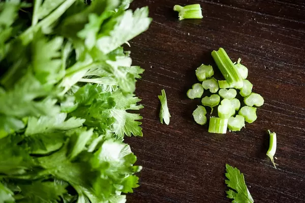 Top View Photo of Chopped Celery next to Bunch of Parsley on Wooden Table