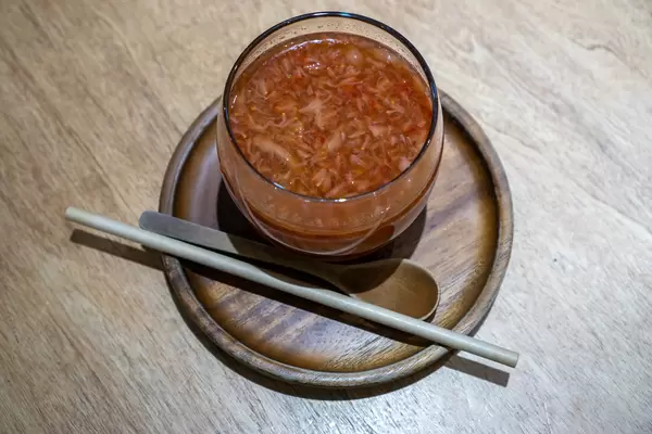 Top View Photo of Hot Strawberry Tea with Paper Straw and Wooden Spoon on a Wooden Saucer