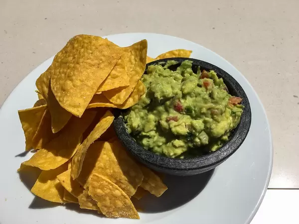 Top View Photo of Nachos on a white Plate with Avocado Dip