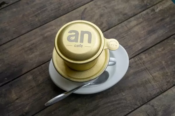 Top View Photo of Vietnamese Hot Coffee with Saucer and Spoon on a Wooden Table