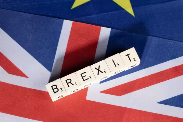 Top View Photo of Wooden Cubes forming the word Brexit on United Kingdom and European Union flags