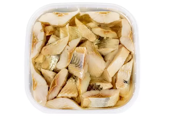 Top view, pieces of pickled herring in oil