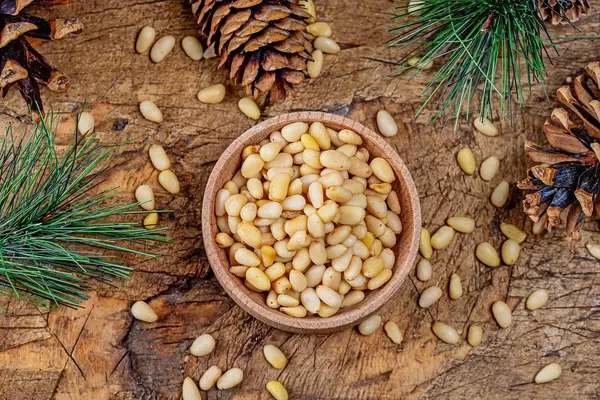 Top view, pine nuts with cones and pine branches on an old wooden background (Flip 2020)