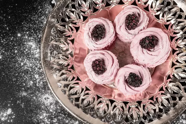 Top view, pink marshmallow with blackberries on an old metal tray