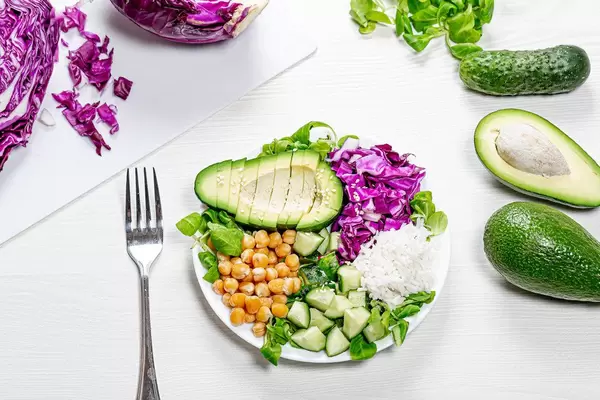 Top view plate with chickpeas, rice with chopped fresh vegetables