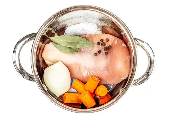 Top view, raw chicken fillet with vegetables and spices in a saucepan