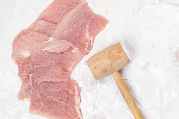 Top view raw meat with wooden hammer on the table