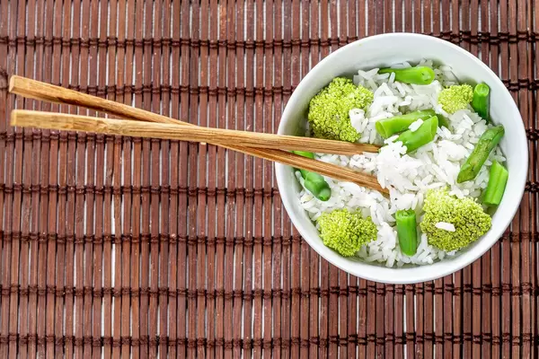 Top view rice with asparagus and broccoli in a bowl with chopsticks (Flip 2019)