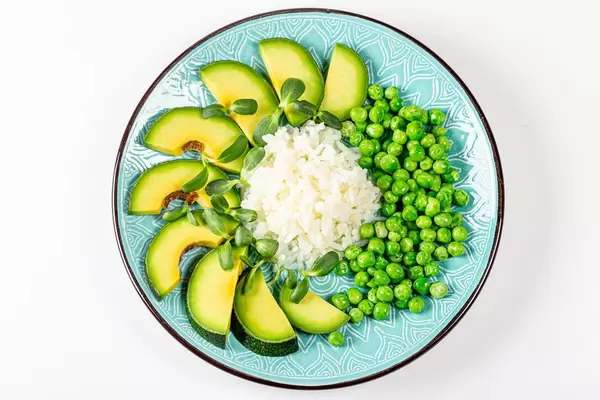 Top view rice with avocado, green peas and sunflower microgreen on a white background (Flip 2020)