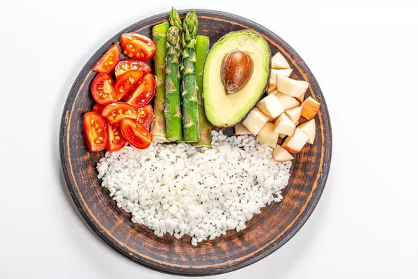 Top view, rice with avocado, tomatoes, asparagus and apples