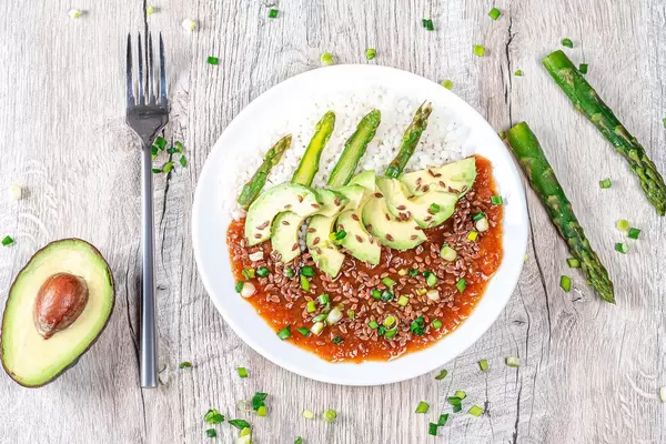 Top view. Rice with tomato-Apple sauce, flax seeds and vegetables on a wooden background (Flip 2019)
