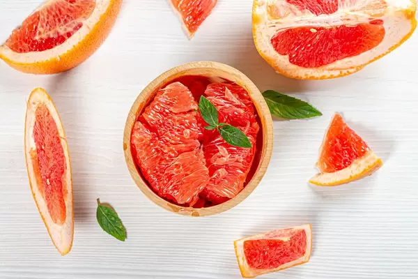 Top view ripe fresh grapefruit slices on white wooden background (Flip 2019)