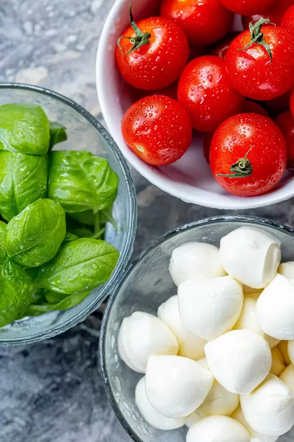 Top view ripe tomatoes, fresh garden basil and mozzarella cheese