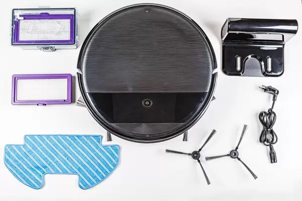 Top view, robot vacuum cleaner and set of its accessories on white