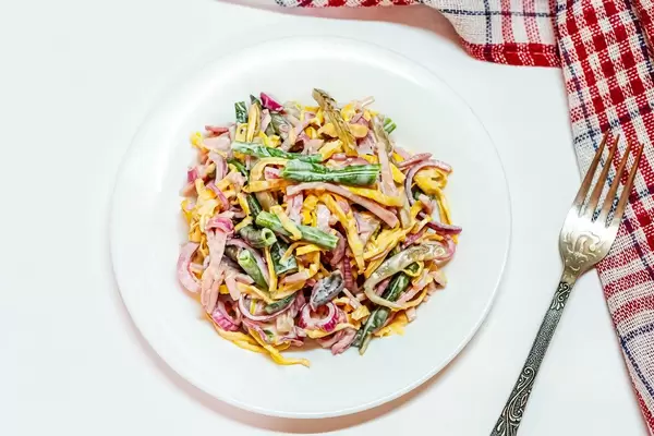 Top view salad with egg omelet, ham and vegetables
