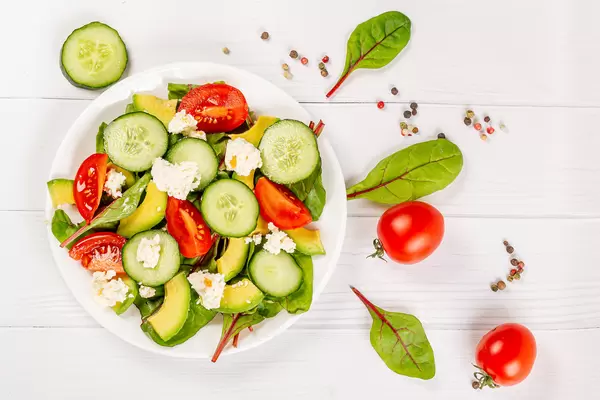 Top view, salad with fresh herbs, chopped vegetables and cottage cheese