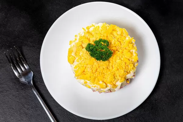 Top view salad with vegetables, ham and sauce on black background with fork (Flip 2019)