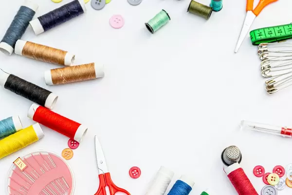 Top view, sewing kit with threads, needles, pins and buttons with free space