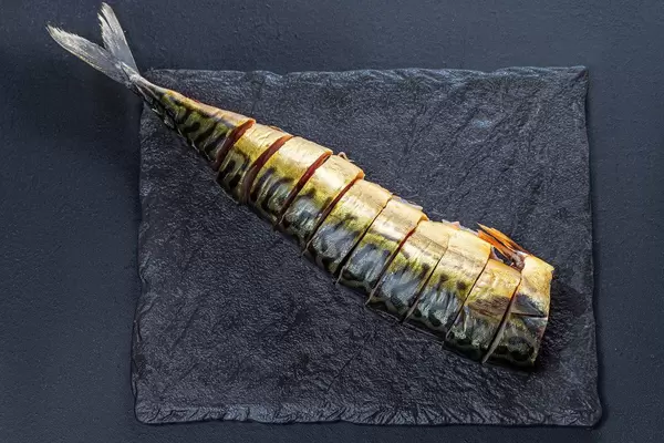 Top view sliced pieces of smoked mackerel on a black background (Flip 2019)