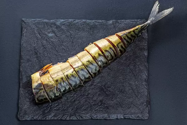 Top view sliced pieces of smoked mackerel on a black background