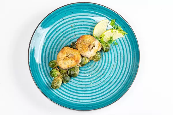 Top view slices of fried hake with Brussels sprouts