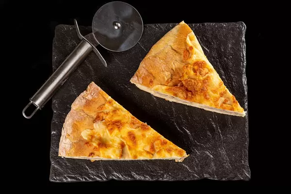 Top view, slices of khachapuri with meat and mozzarella on dark background