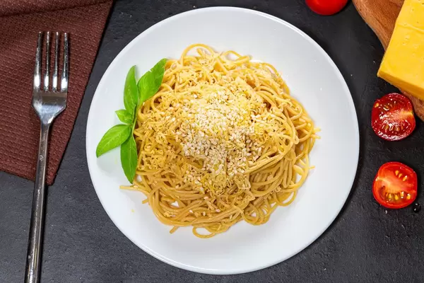 Top view spaghetti with cheese, sesame seeds and Basil leaves on a black background (Flip 2019)