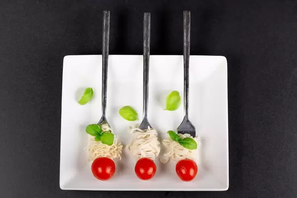 Top view, spaghetti with fresh cherry tomatoes and basil leaves
