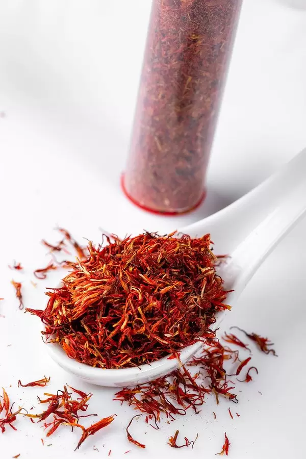 Top view spice saffron in a white spoon and on white background