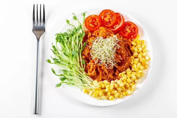 Top view, stewed cabbage with micro greenery and vegetables on a white background (Flip 2020)