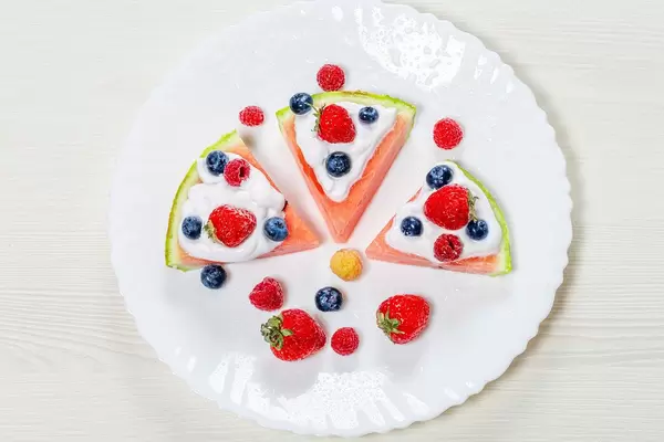 Top view, strawberries, raspberries, blueberries and white cream on slices of ripe watermelon (Flip 2019)