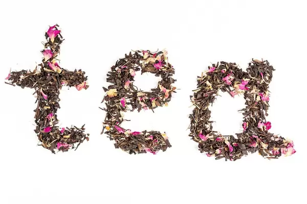 Top view, the inscription tea made from dried tea on a white background