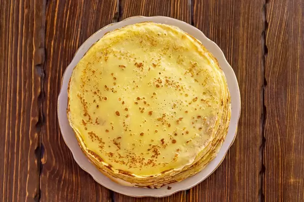 Top view, thin fried pancakes on wooden background