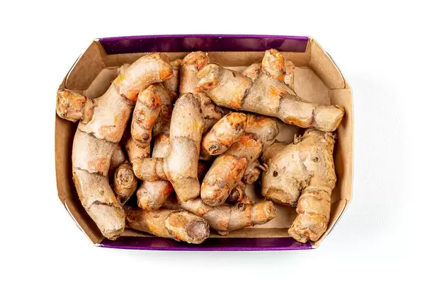Top view, turmeric root in a box on a white background (Flip 2020)