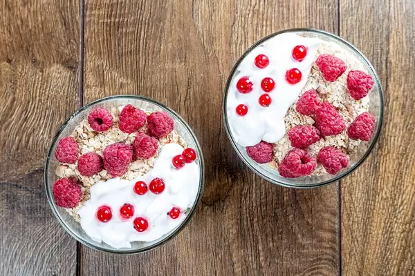 Top view two bowls of oatmeal with fresh berries on a brown wooden background (Flip 2019)