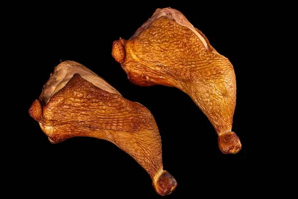 Top view, two smoked chicken quarters on black
