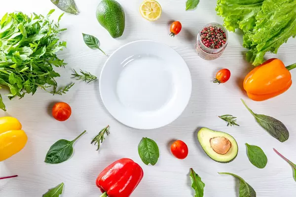 Top view vegetables, herbs and spices around a white plate. Healthy eating concept