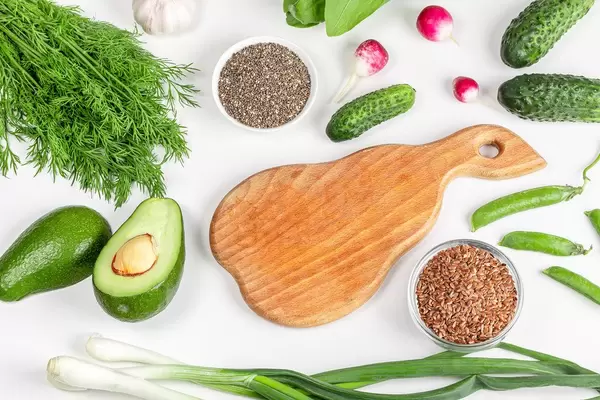 Top view, vegetarian fresh food and kitchen board on white