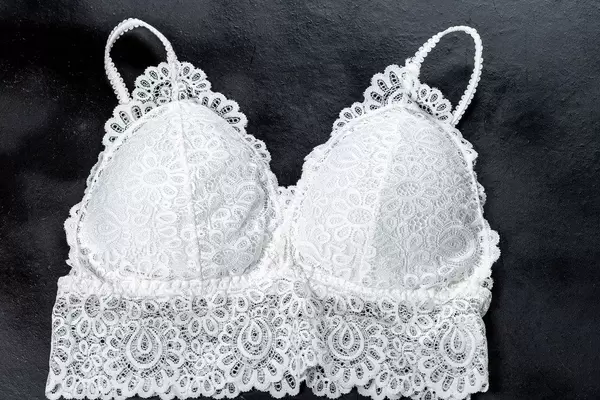 Top view white lace top bra on black background (Flip 2019)